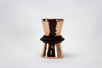 a photograph of a lamp made of copper against a white backdrop