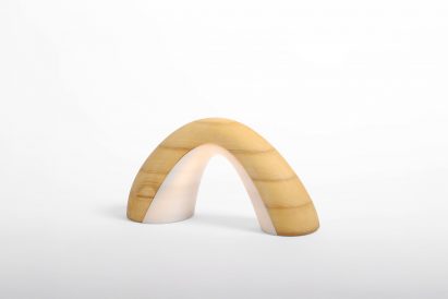 a photograph of a lamp, in the shape of an arch, in tones of beige and white against a white backdrop