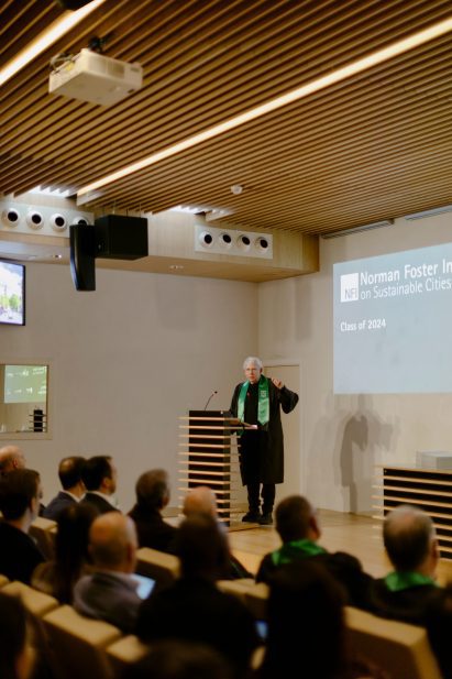 A lecturer giving a lecture to a room full of students