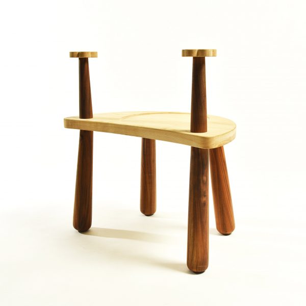 a photograph of a brown wooden stool with elongated legs