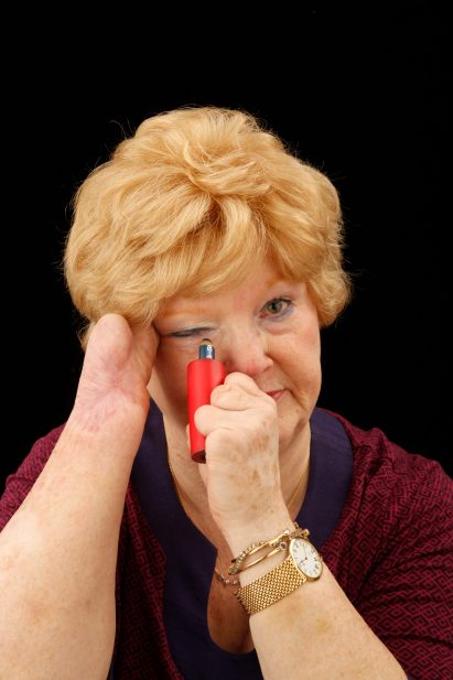 Cindy, as part of the Engineering at Home project, uses a prosthetic to put on her eyeliner