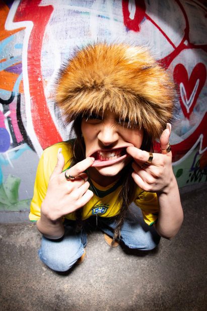 a photograph of a person facing the camera with a brown fluffy hat on