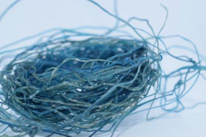 a photograph of bundled strings of materials in tones of blue
