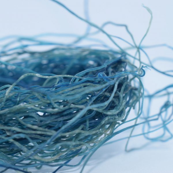 a photograph of bundled strings of materials in tones of blue
