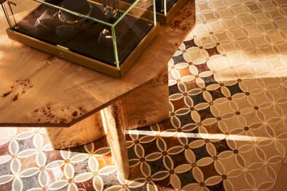 Burl wood table on a patterned tiled floor in Azza Fahmy boutique 