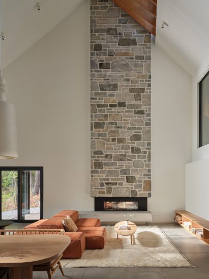 Stone chimney in living area of lakeside Muskoka cabin