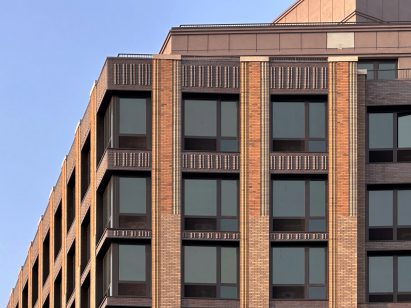 Close-up of One Park Point façade featuring Belden Brick's sawtooth brick shapes. Detail shows contemporary brick architecture with textured pattern between windows, highlighting the dimensional brick installation technique.