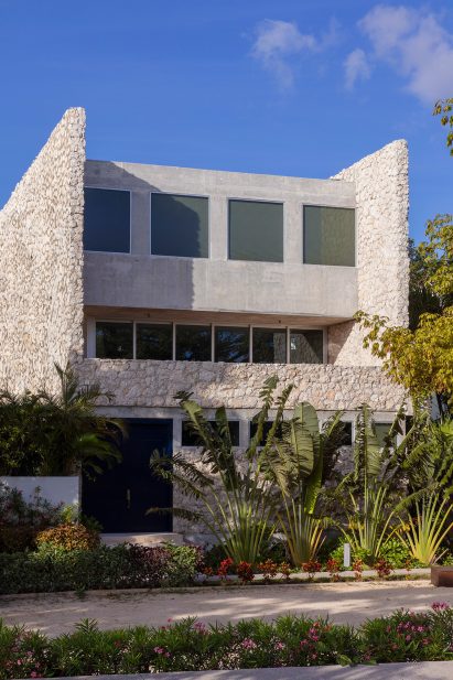 House with limestone walls and tropical planting in front