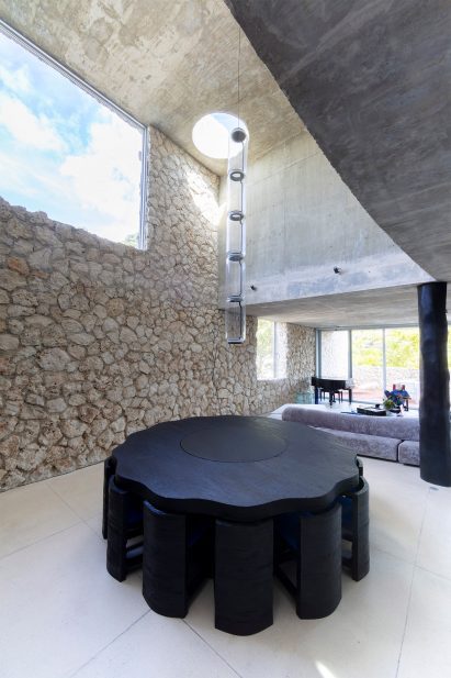 A large dining table sits in a double-height space
