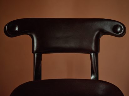 Backrest of dark-stained chair by Antoni Gaudí