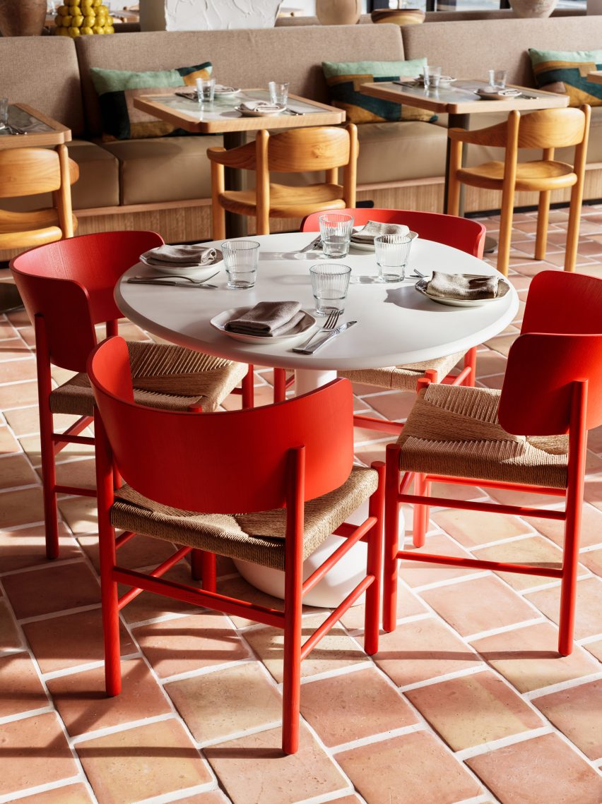 Red chairs over thick terracotta floors in restaurant by Luchetti Krelle