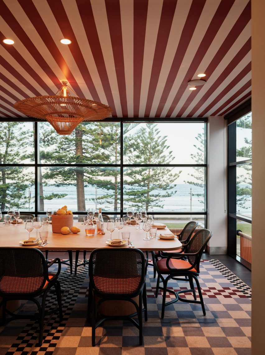 Private dining space overlooking the sea with red and white striped ceiling