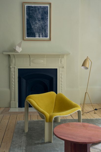 Yellow chair next to fireplace