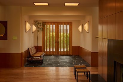 Entryway with slatted from doors and black flagstone flooring