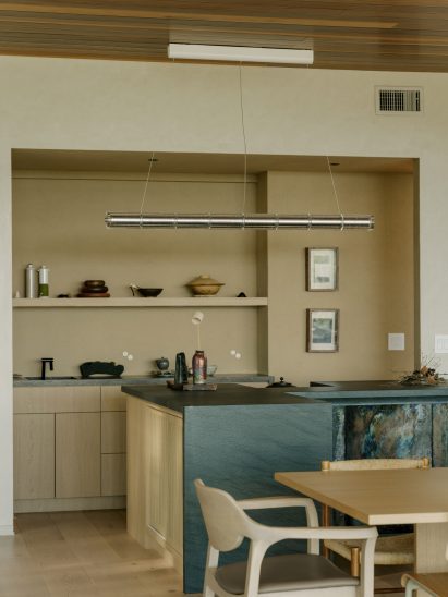 A tea bar in a dining room with textured green stone and custom ceramic tiles