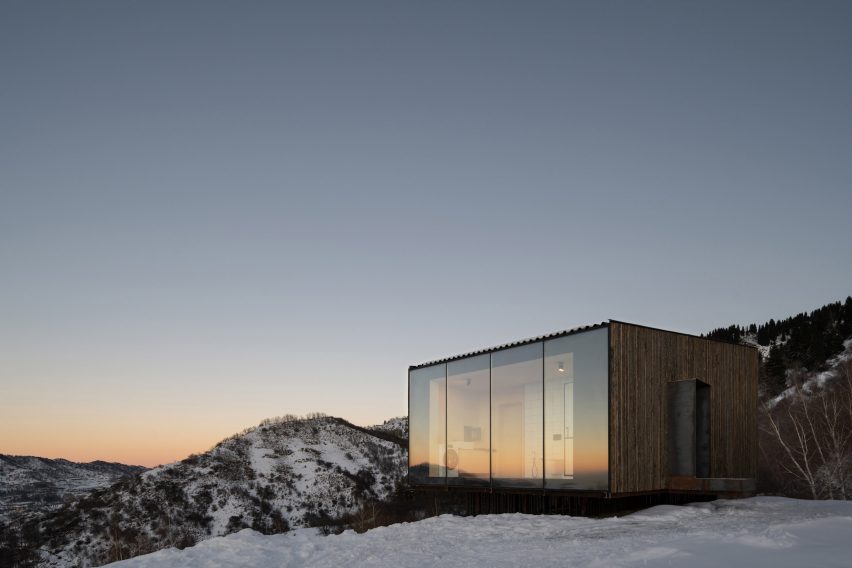 Lit-up wooden cabin in snowy landscape