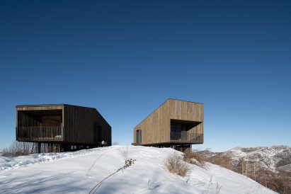 Wooden cabins on snowy hill