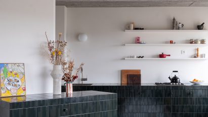 Kitchen clad in blue and green tiles
