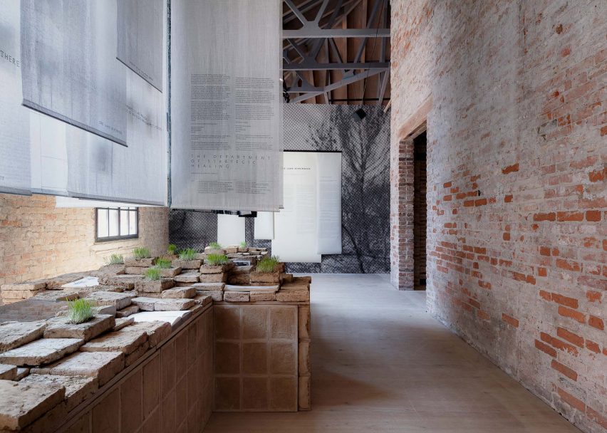 Photo of the display at the Lebanese pavilion at the Venice Architecture Biennale 2025, showing greenery sprouting from some of the bricks