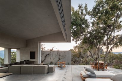 Living room with grey stucco surfaces connected with a large outdoor terrace