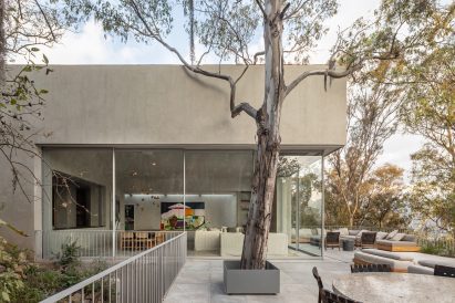 House surrounded by a large patio with trees growing up through gaps