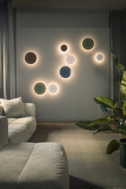 a photograph of circular coloured lights on a wall next to a sofa