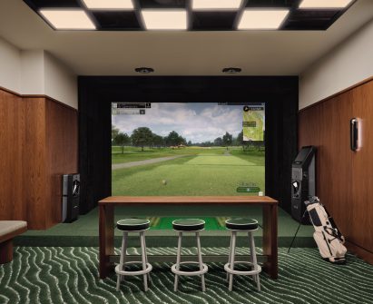 Golf simulator with green carpet and red oak panelling