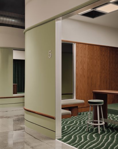 Golf simulator room with a curved corner and pale green outer wall