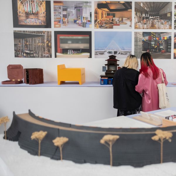 a photograph of two people viewing artwork on a wall