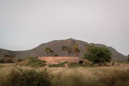 Half-buried concrete building within a desert landscape
