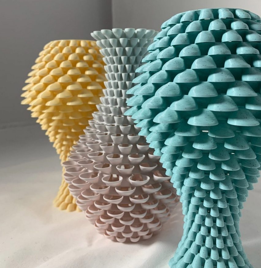 a photograph of three textured sculptures in abstract shapes, in tones of yellow, grey and blue