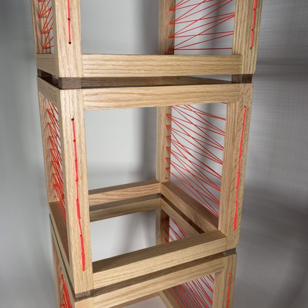 a photograph of hollow wooden cubes stacked on top of each other, featuring orange weaving