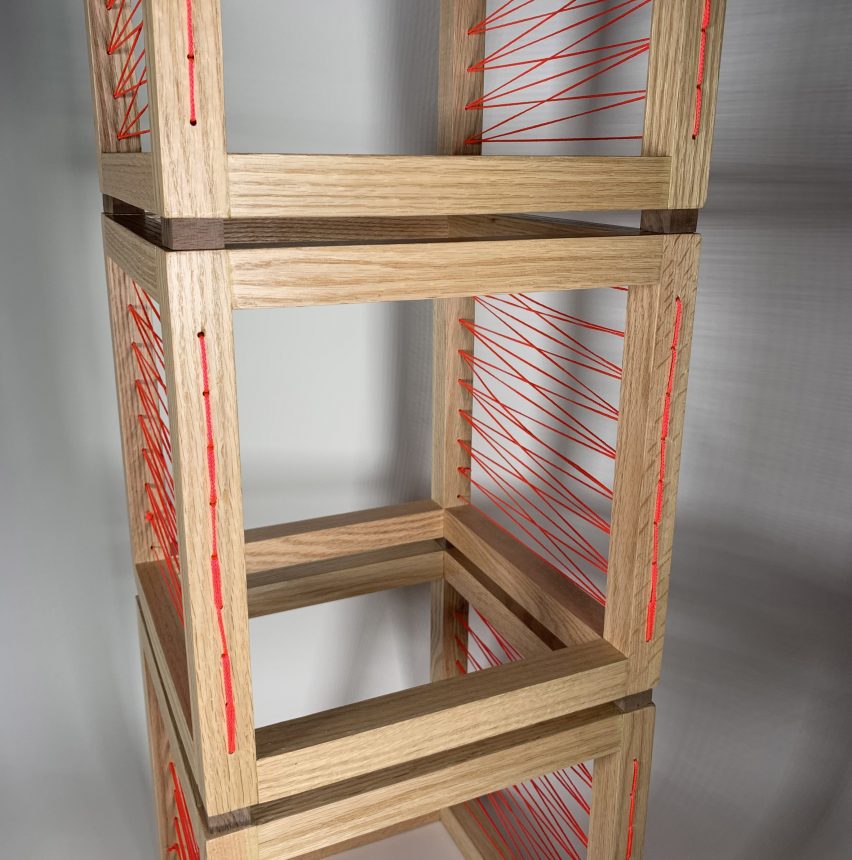 a photograph of hollow wooden cubes stacked on top of each other, featuring orange weaving