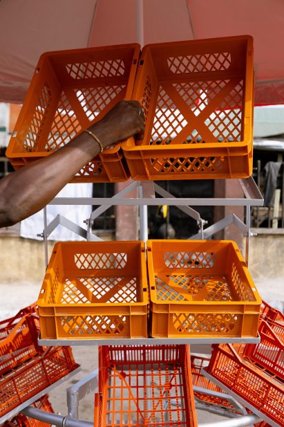 Man putting orange crates into a metal frame