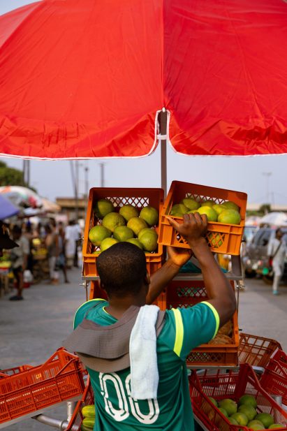 Man putting crate of fruit into a stall