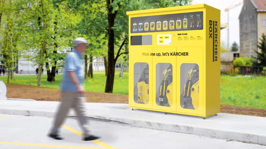 a photograph of a person walking past a large yellow box in a park