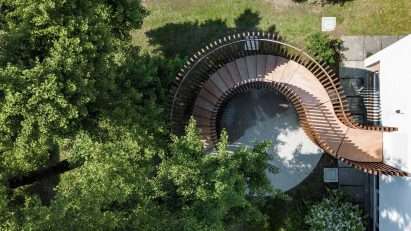 a visualisation from above of a brown wooden pavilion in a green space