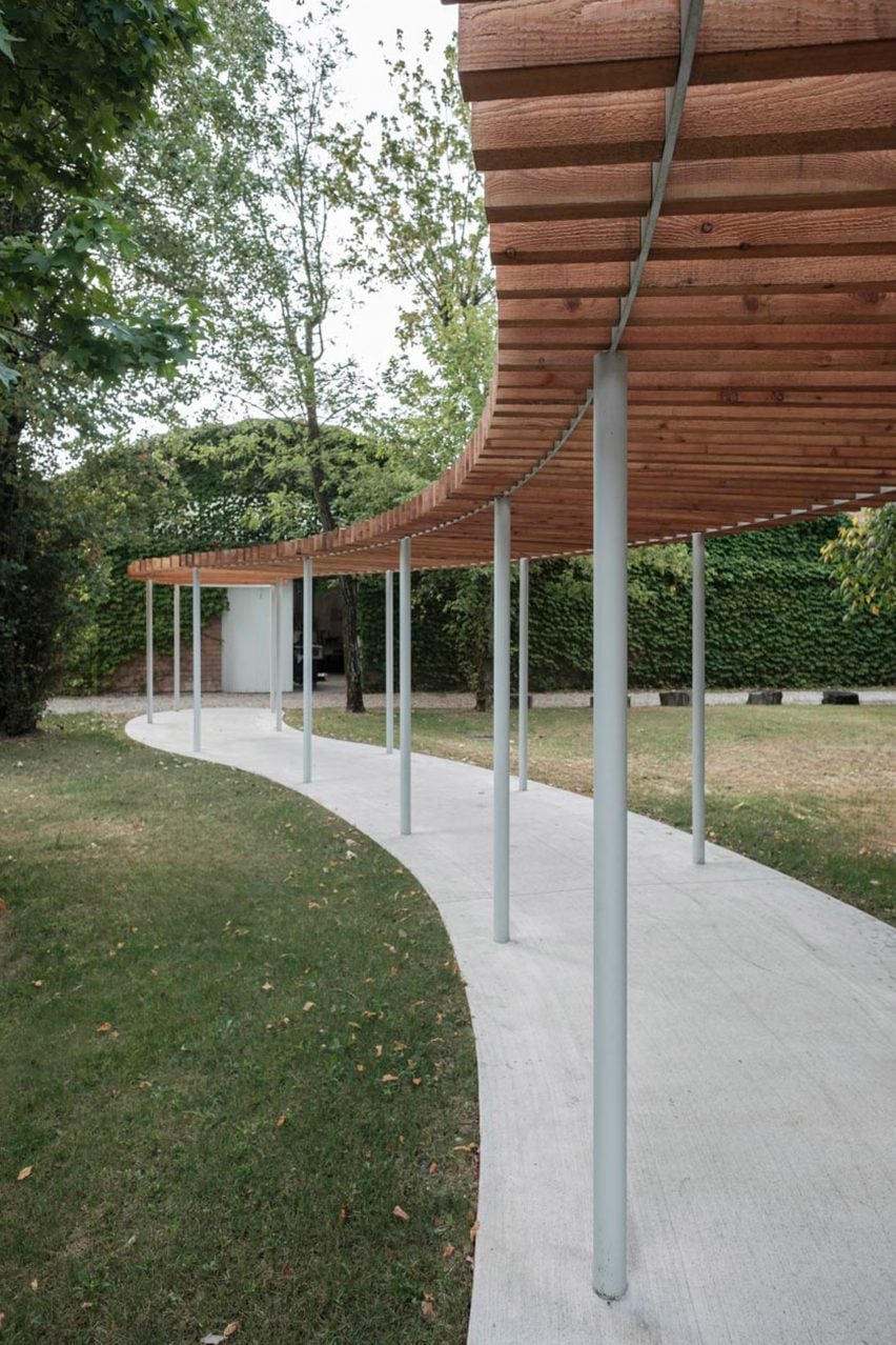 a visualisation of a pavilion in tones of grey and brown amongst a green garden