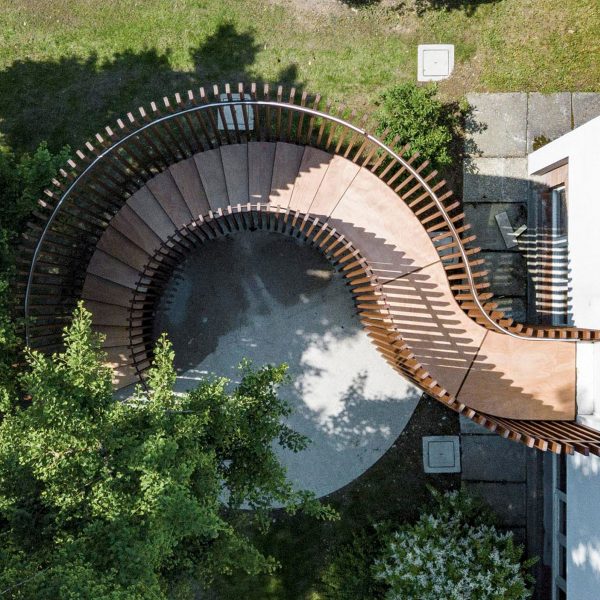a visualisation from above of a brown wooden pavilion in a green space
