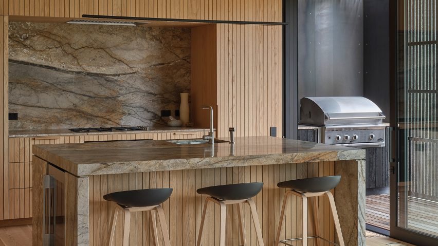 Kitchen featuring an island bench clad in marble