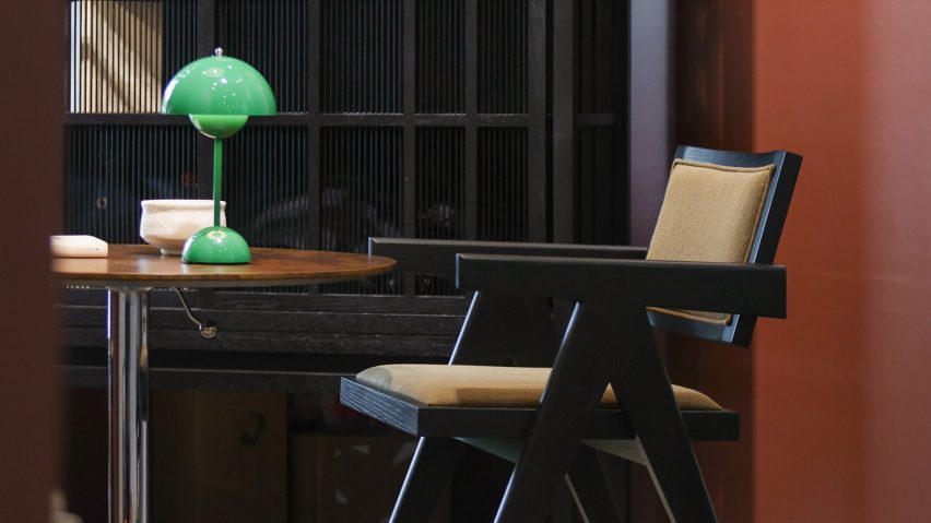 Photo of a black and beige chair, a table and a green lamp