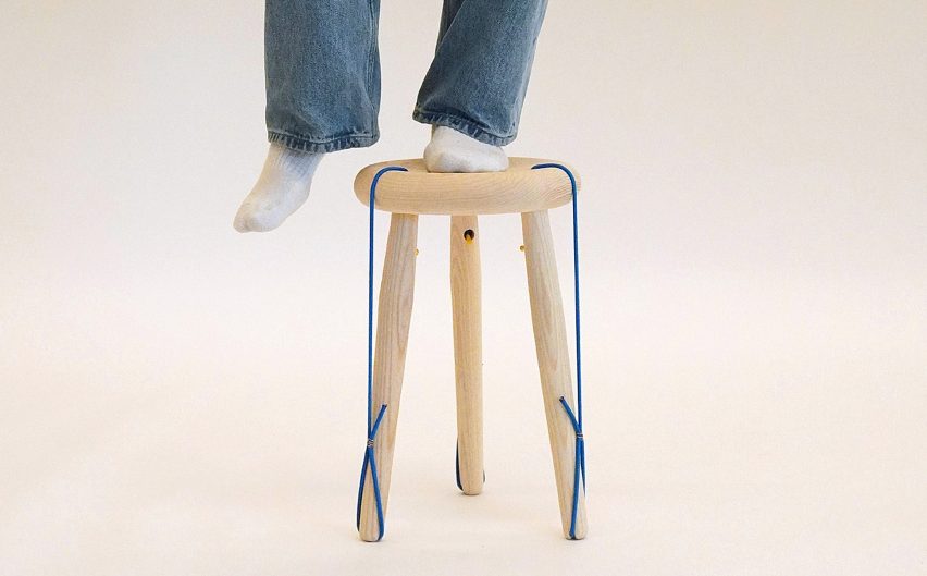 Photo of legs, with one standing on a light wood stool