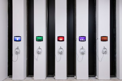 Photo of headphones and screens on narrow walls