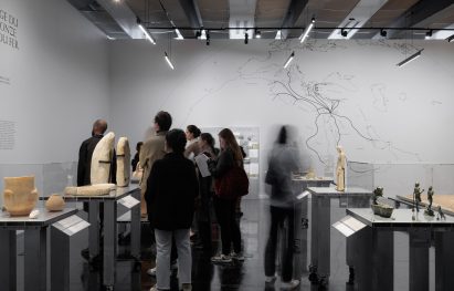 Photo of a roomful of visitors at a gallery for the Treasures Rescued from Gaza exhibition