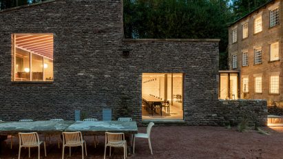 Stone building with long dining table in front of it