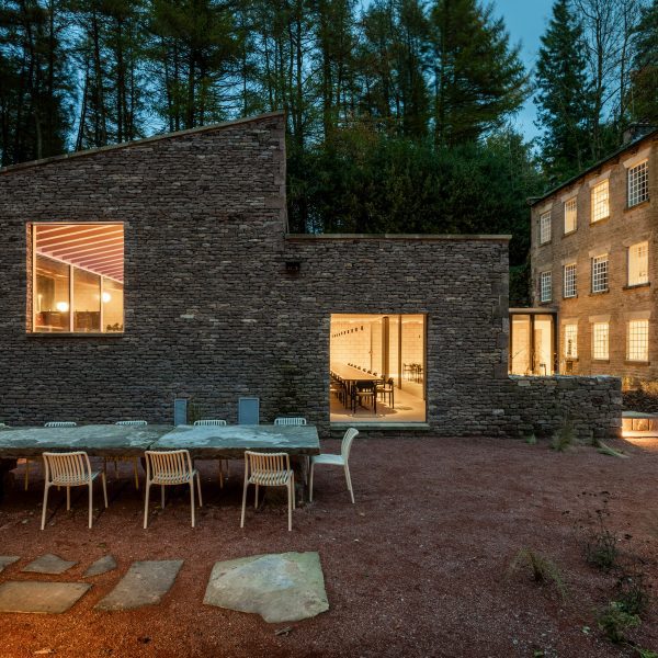 Stone building with long dining table in front of it