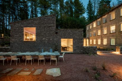 Stone building with long dining table in front of it