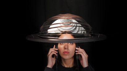 a photograph of a person wearing a spherical headpiece device 
