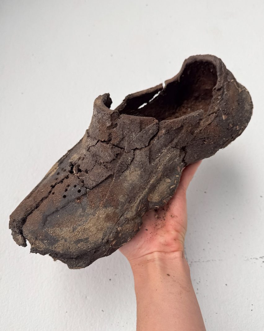A person holding a shoe made out of dirt