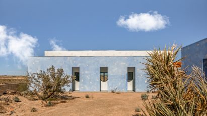Facade of a single-story building covered in sky-blue, textured cat-face stucco